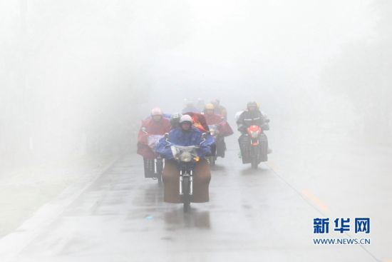 　大雾弥漫，山里下起了小雨，摩托车极易打滑，但回家心切的铁骑大军依然冒雨行驶(资料照片)。 新华社发